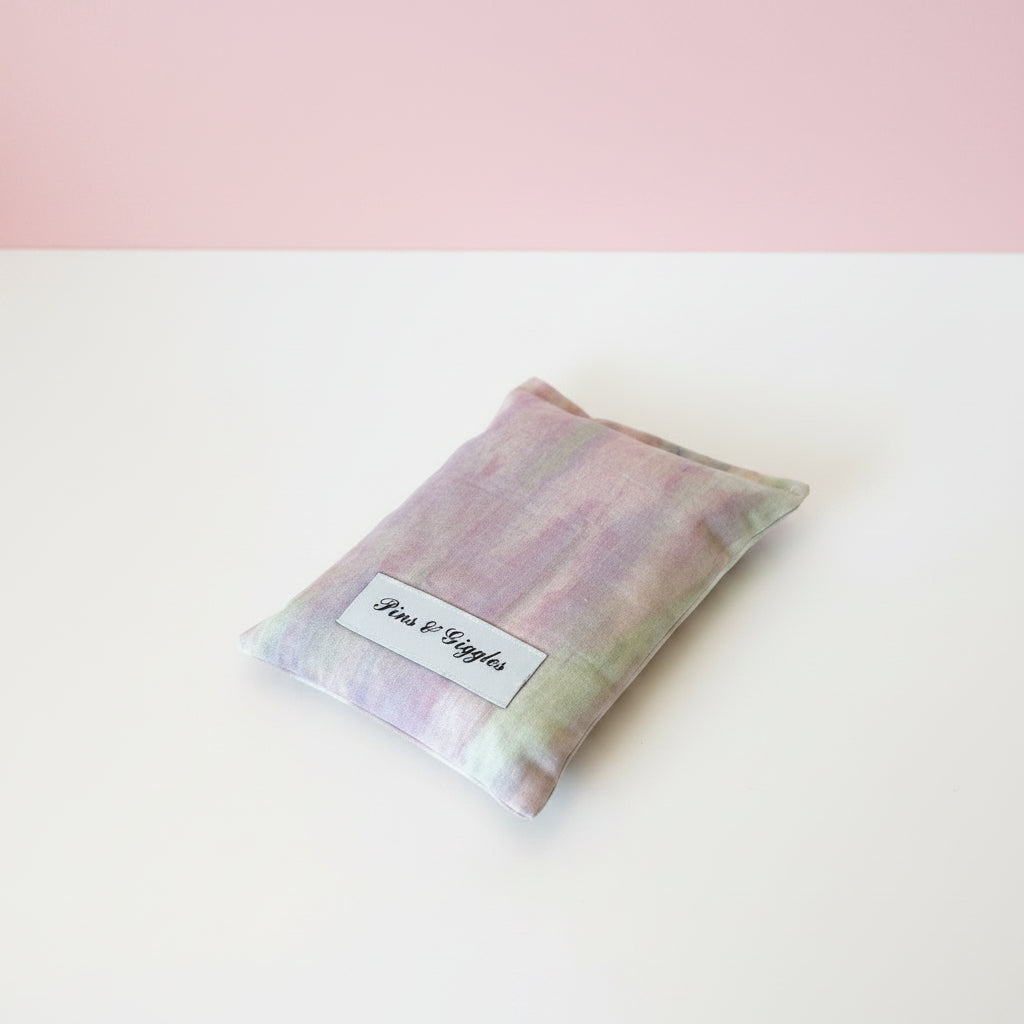 tie dye pouch with 'Pins & Giggles' label on a white surface