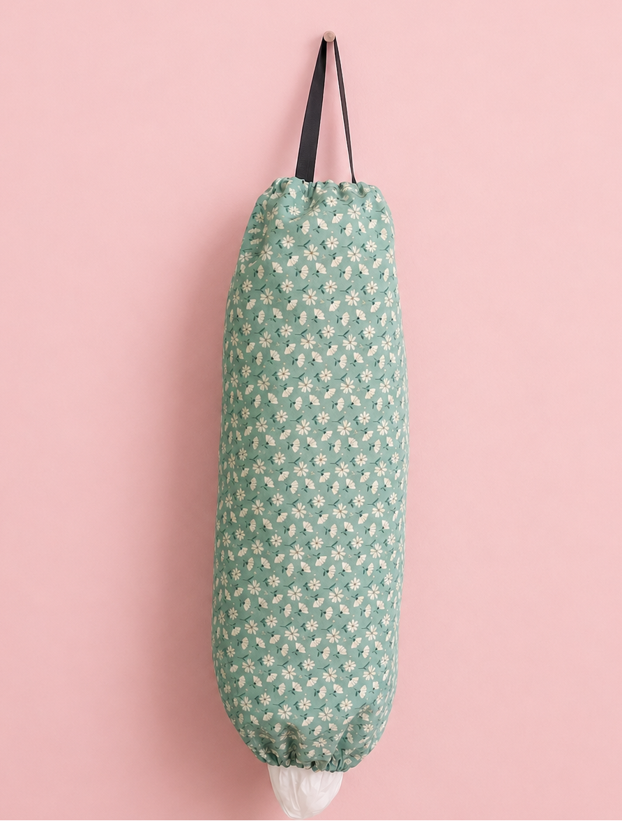 Green patterned fabric grocery bag holder on a pink background