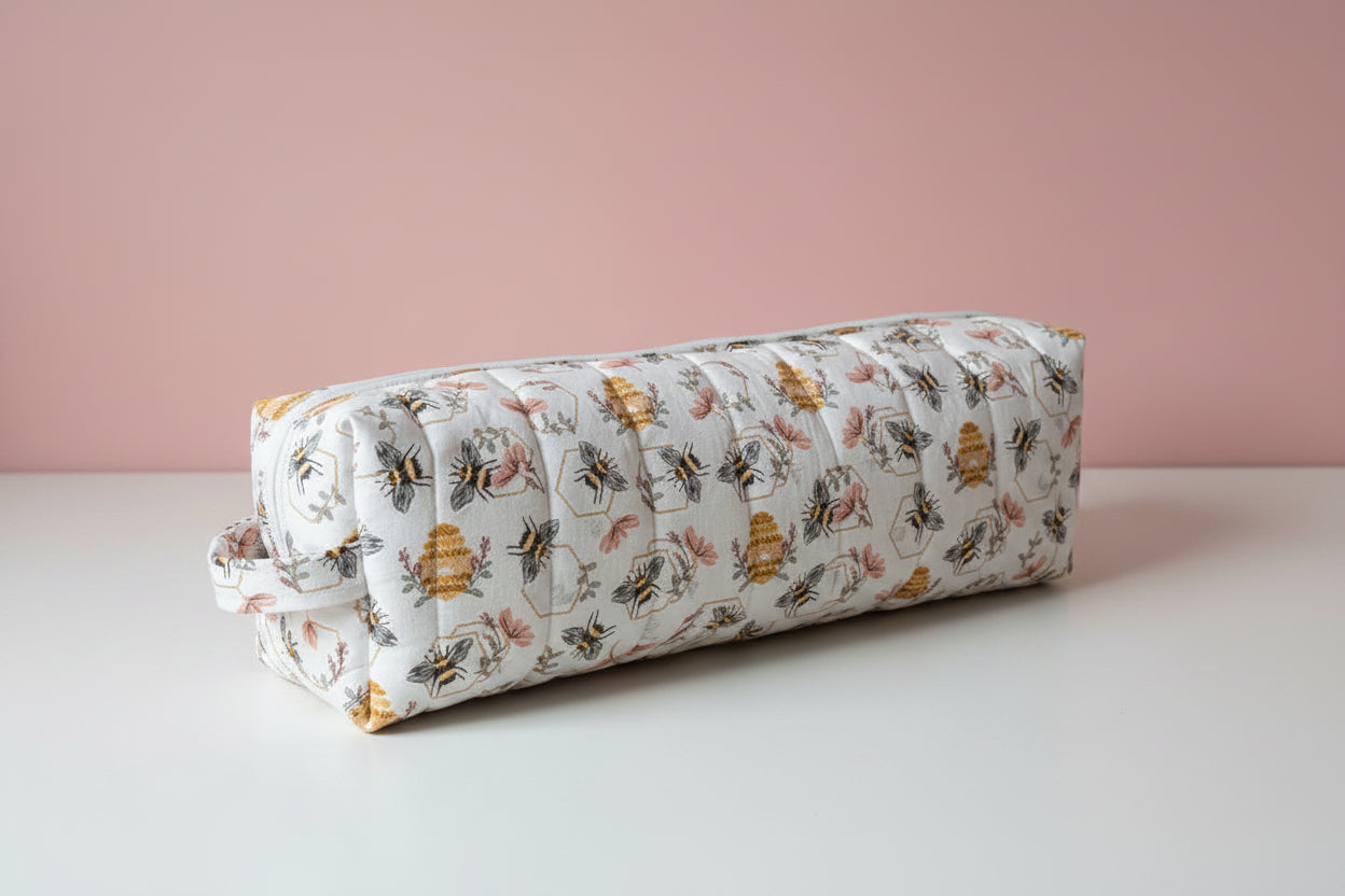 fabric hair tool bag on a white surface with a pink background