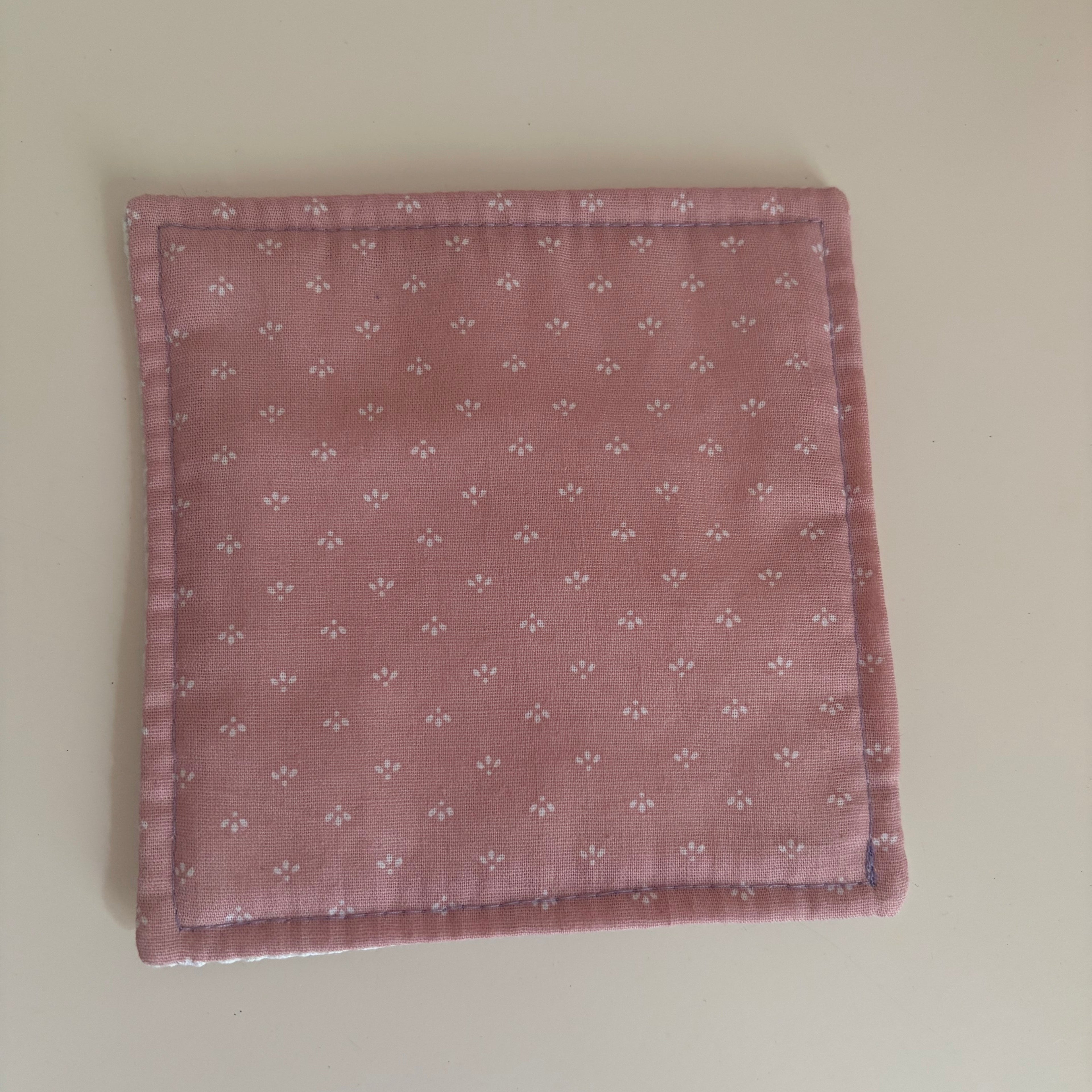 pink fabric jar gripper with a subtle pattern on a white background