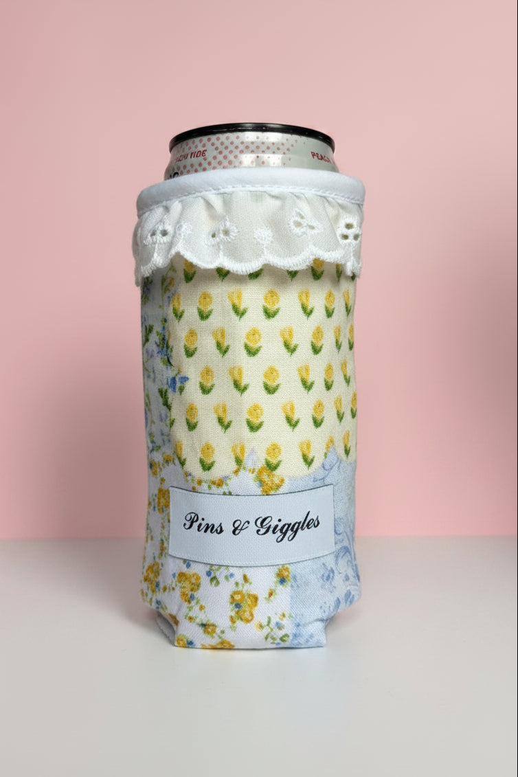 can cooler with floral pattern and lace design on a white surface with pink background