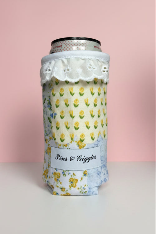 can cooler with floral pattern and lace design on a white surface with pink background