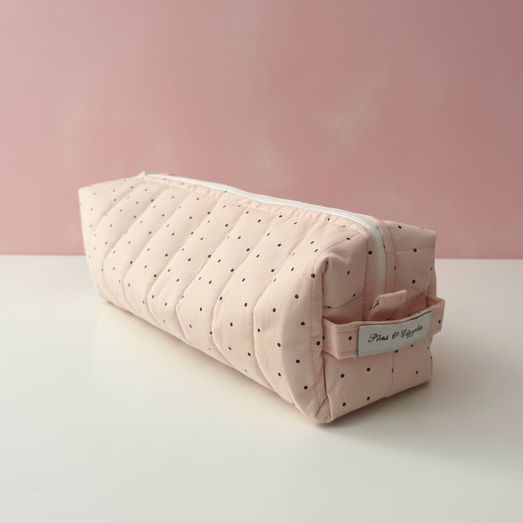 Pink polka dot fabric hair tool bag with visible brand name.