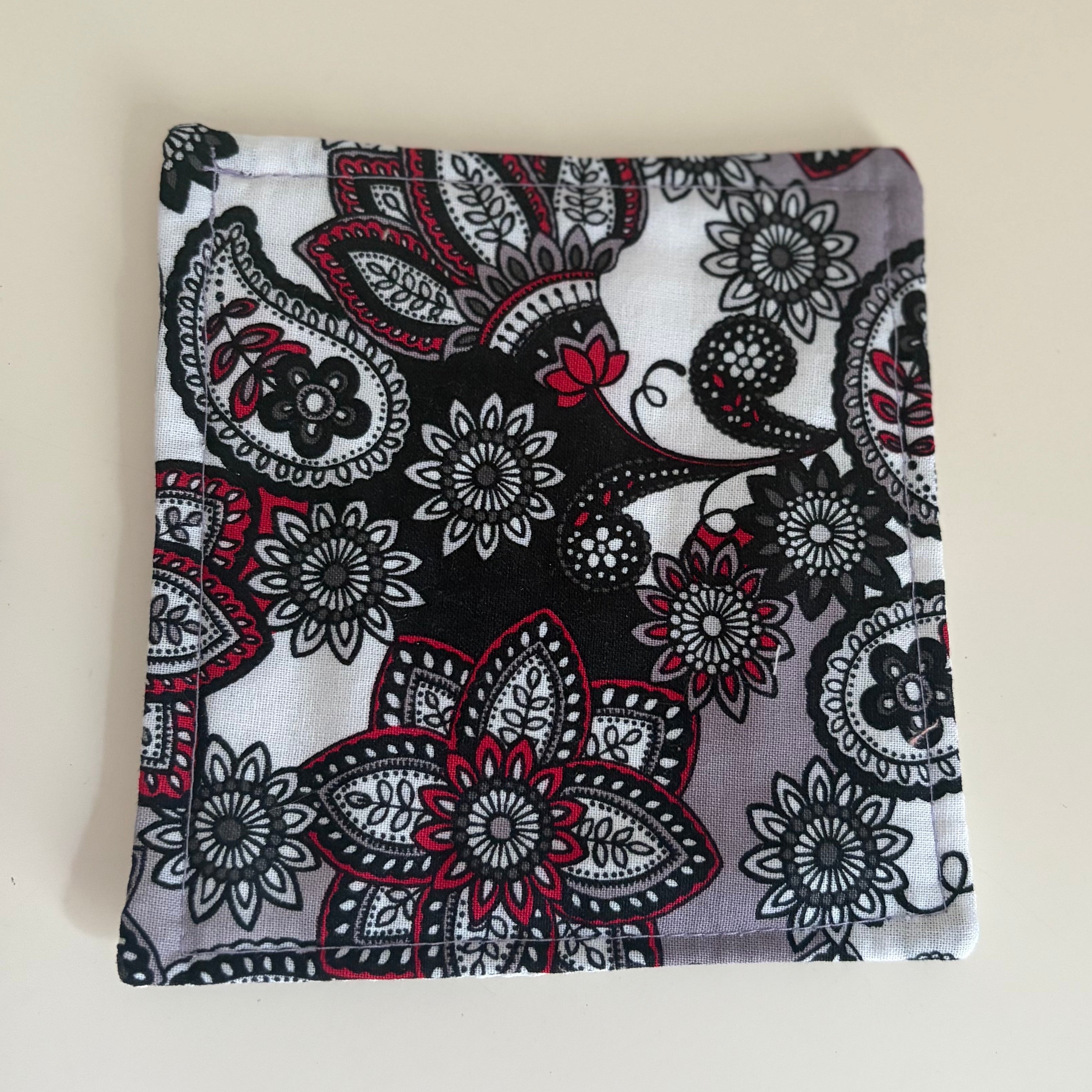 Fabric with black and pink floral pattern, jar gripper on a white background