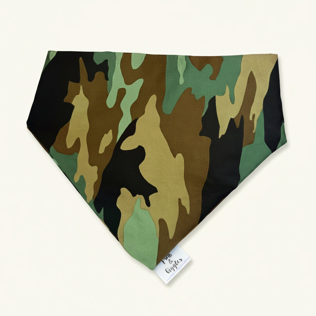 Camouflage bandana on a wooden surface with a pink background