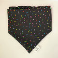 Black bandana with colorful polka dots on a white surface