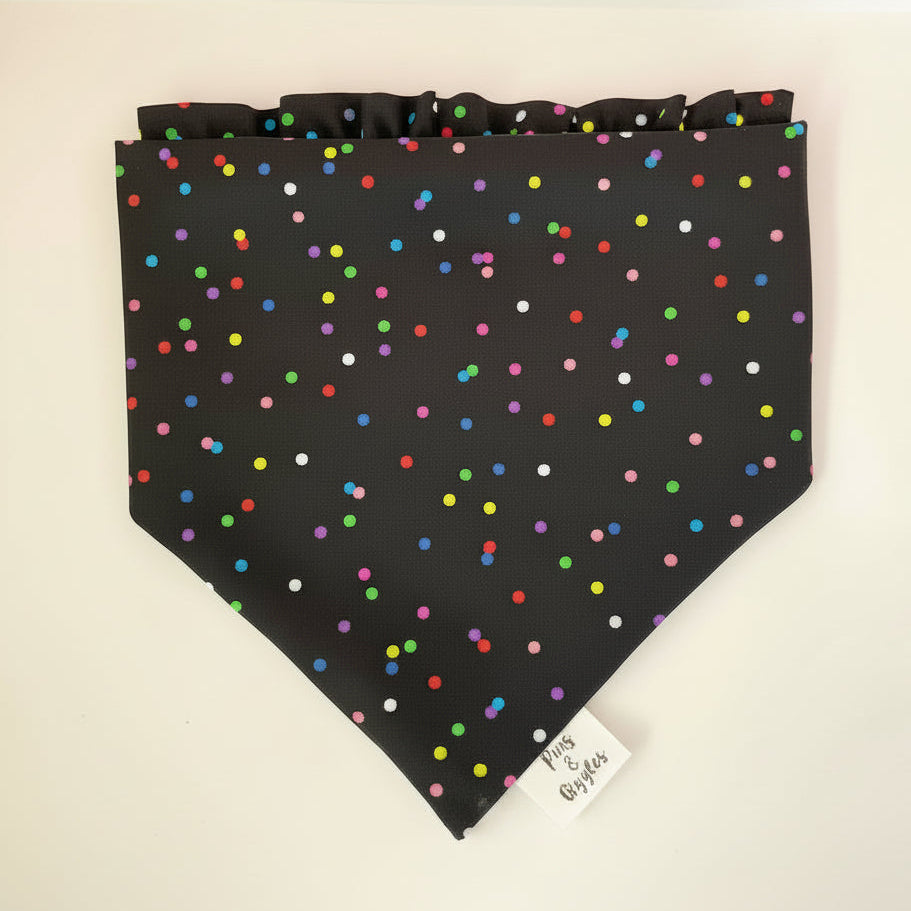 Black bandana with colorful polka dots on a white surface