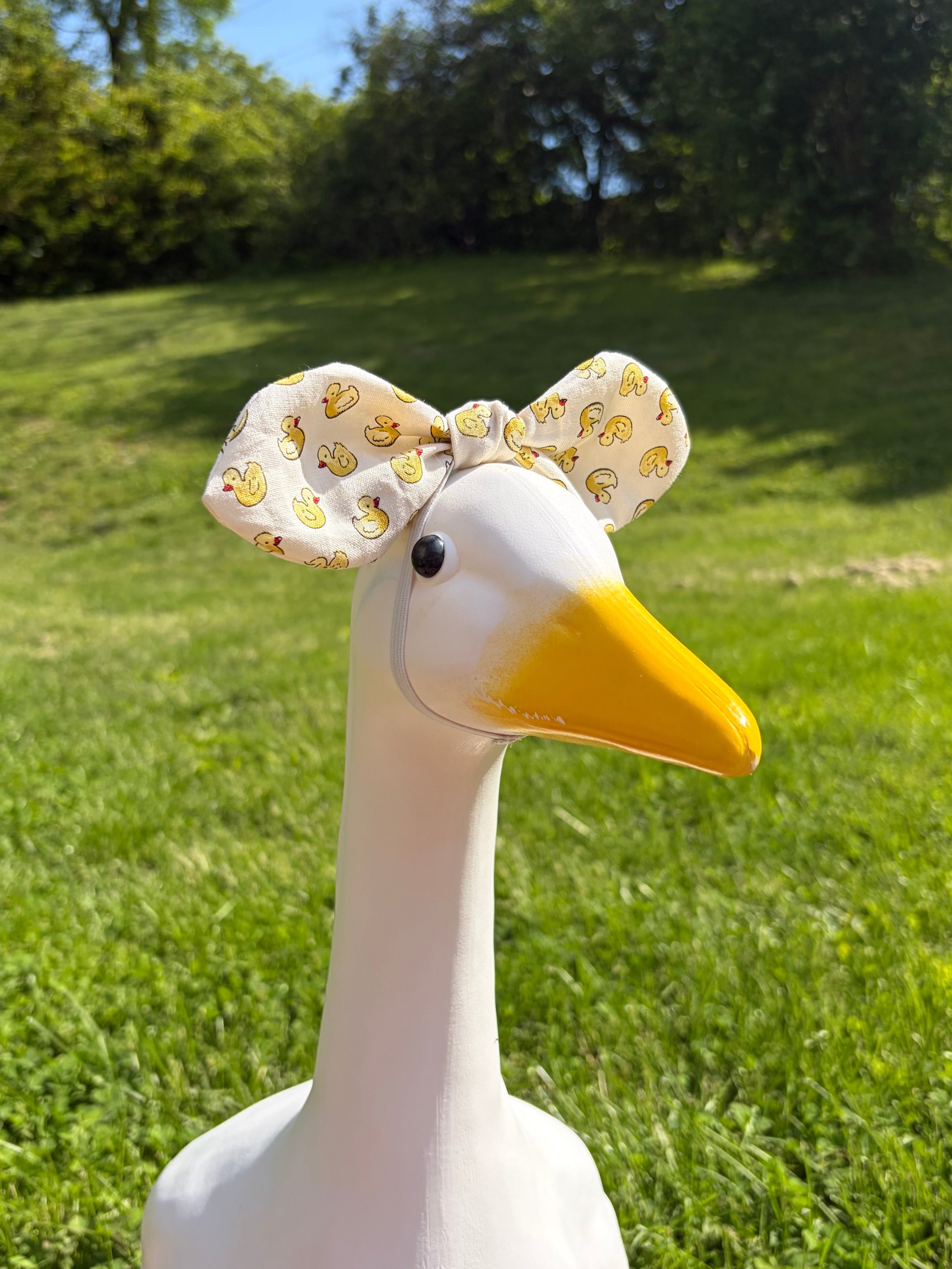 porch goose with a bow made out of tiny rubber duck patterned fabric