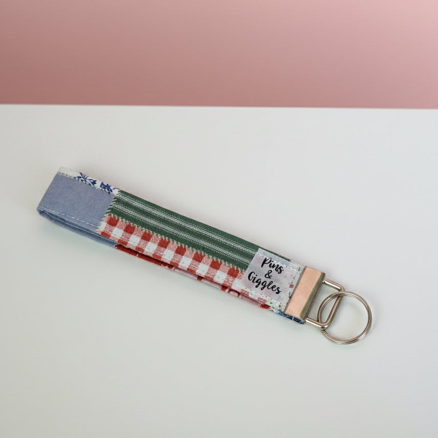 Keychain with striped fabric strap on a white surface
