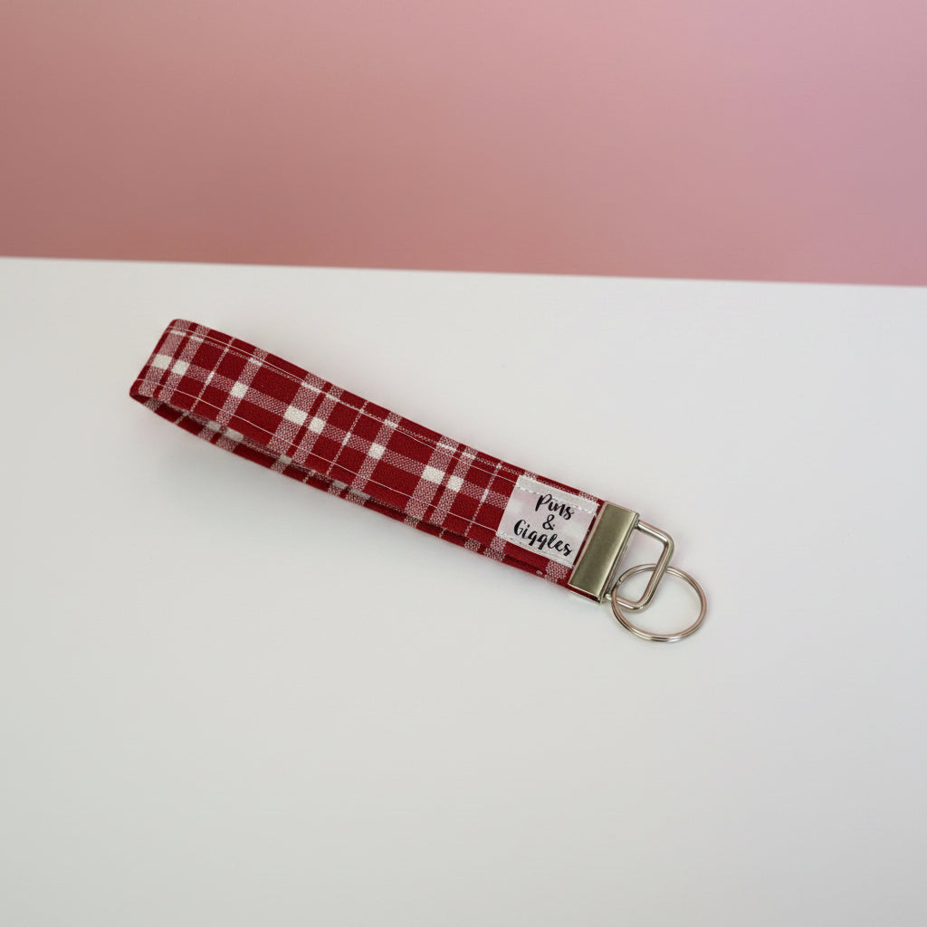 Red plaid keychain with a metal clasp on a white surface